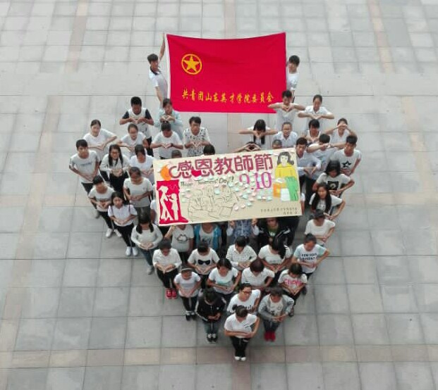 活动人员在团旗下以心形队形拍照合影