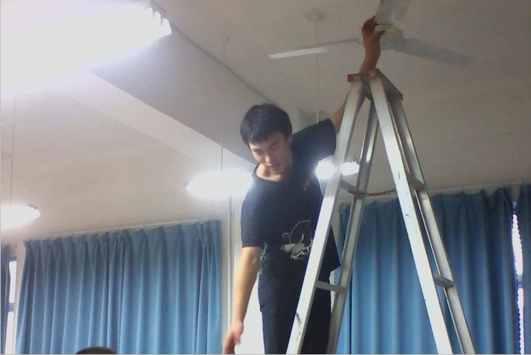 认真擦拭风扇的校学生会成员